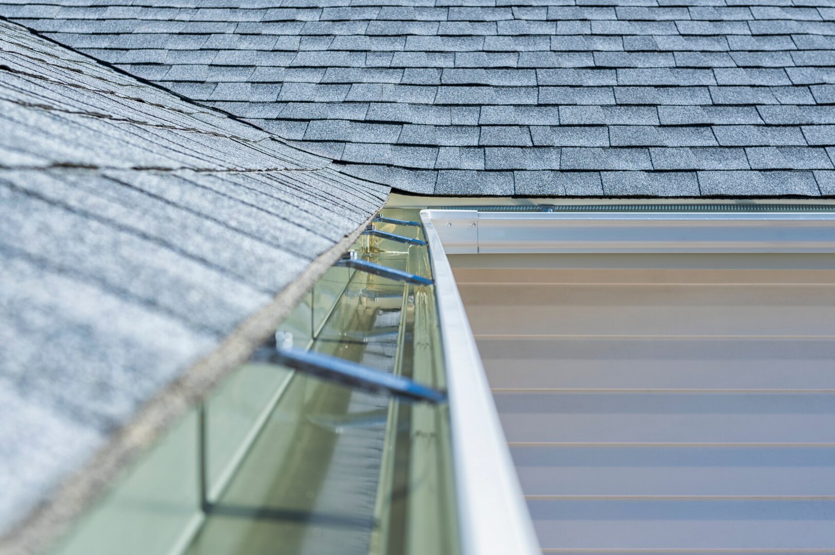 Long gutter run fitted beside a shingle roof