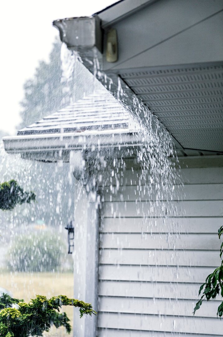 Residential gutter overflowing during heavy rain