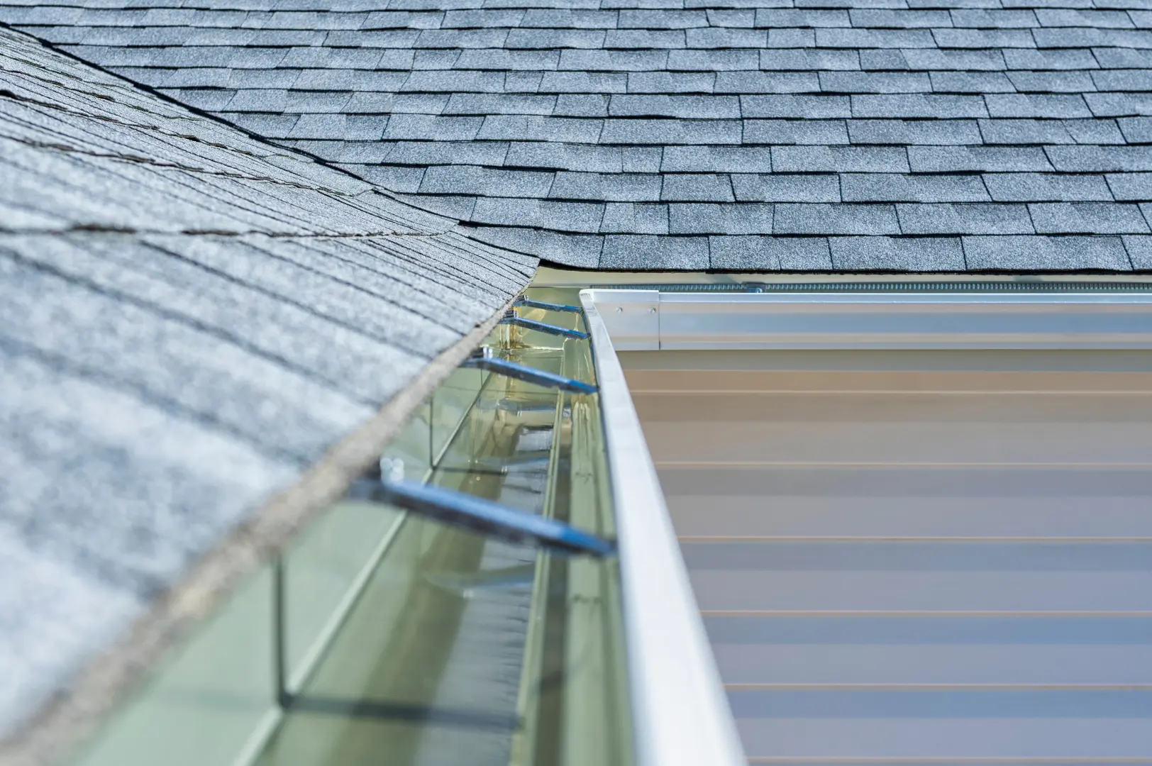 Long gutter run fitted beside a shingle roof